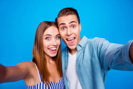 Self-portrait of her she his he two nice attractive lovely charming cheerful cheery glad excited people embracing isolated over bright vivid shine vibrant blue color backgroundの写真素材