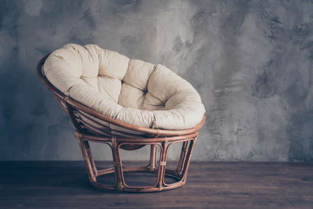 Portrait of modern contemporary household furniture wicker chair perfect for rest relax leisure recreation isolated over grey wall backgroundの写真素材