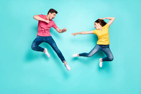 Full length body size view of nice attractive sportive crazy cool strong couple having fun fighting in air contest discount isolated over bright vivid shine vibrant green turquoise backgroundの写真素材