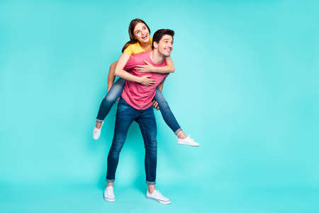 Full length body size view of his he her she nice attractive lovely funny cheerful cheery couple guy carrying girl having fun time isolated over bright vivid shine vibrant green turquoise backgroundの写真素材