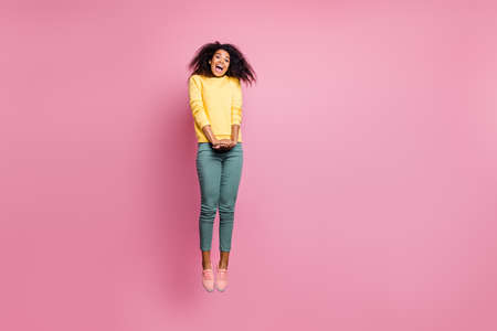 I love shopping concept. Full length photo of pretty adorable sweet amazed surprised hipster teen girl jumping up screaming to you wearing sweatshirt isolated pastel color backgroundの写真素材