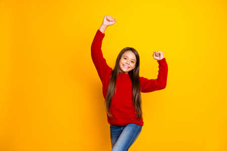 Photo of cheerful cute nice rejoicing schoolchild happy with having got good, mark at school wearing jeans denim isolated over vivid color yellow backgroundの写真素材