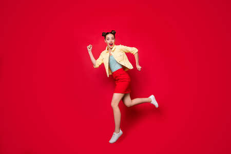 Full length photo of pretty jumping lady running fastly shopping wear casual outfit isolated red...