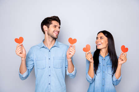 Photo of trendy cute charming lovely sweet couple of two people holding small hearts red looking at...