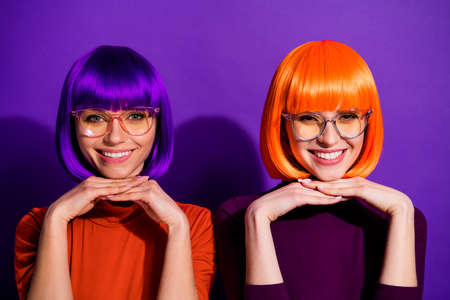 Close-up portrait of two nice attractive charming cute cheerful cheery funny, girls wearing wigs diligent learners isolated over bright vivid shine vibrant purple violet lilac color backgroundの写真素材