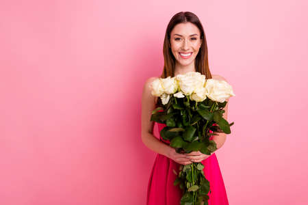 Portrait of her she nice-looking attractive lovely charming cute lovable, feminine cheerful cheery girl holding in hands white roses isolated over pink pastel color backgroundの写真素材
