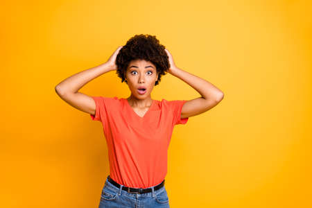 Photo of attractive cute charming pretty girl shocked by new information, having disappointed her wearing jeans denim orange t-shirt isolated vibrant color backgroundの写真素材