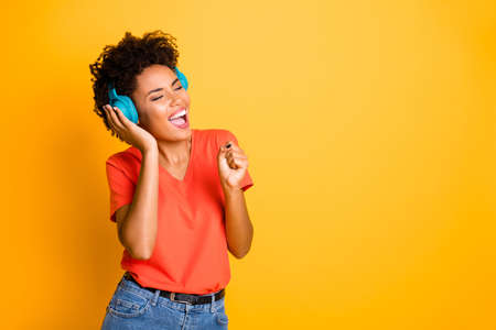 Copyspace photo of curly wavy cheerful charming lady singing into her imaginary, microphone wearing...