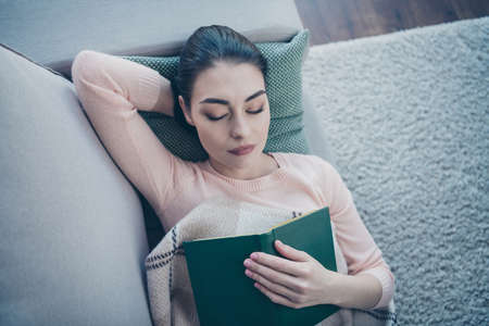 High angle top above photo of pretty lady lying comfy on couch covered with checkered, blanket fell asleep while reading boring bookの写真素材