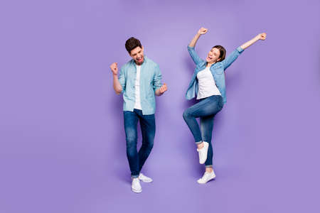 Full body photo of ecstatic spouse feel lucky romance raise fists scream yes celebrate fortune victory on travel trip honeymoon wear modern clothes isolated over purple color backgroundの写真素材