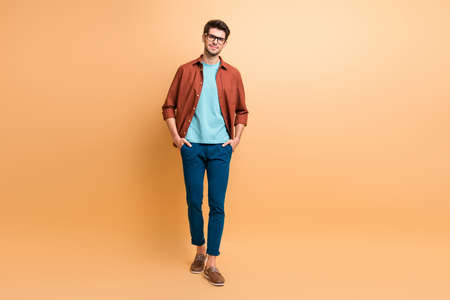 Full length body size view of his he nice attractive calm content brunet guy business shark leader partner expert holding hands in pockets isolated over beige color pastel backgroundの写真素材
