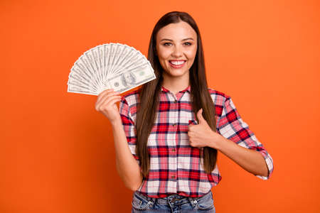 Photo portrait of excited positive satisfied cheerful worker getting high salary making finger up symbol holding pile of money in hand isolated bright color backgroundの写真素材
