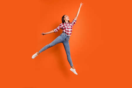 Full size length body photo of attractive charming pretty beautiful charming gorgeous woman jumping up pointing on highest top isolated vibrant color backgroundの写真素材