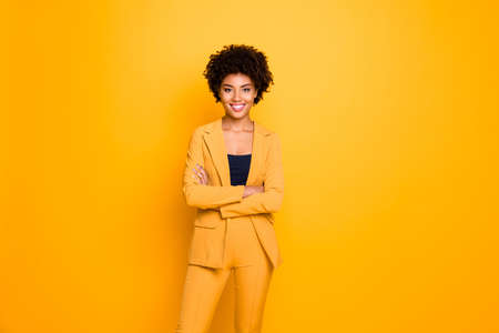 Portrait of her she nice-looking attractive lovely content cheerful cheery wavy-haired girl folded arms spring clothing trend isolated over bright vivid shine vibrant yellow color backgroundの写真素材