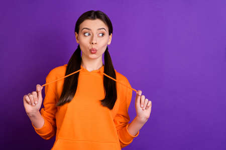 Portrait of funny funky lovely girl look listen wonderful news rumors secret gossip say oops omg wow wear orange sportswear isolated over violet purple color backgroundの写真素材