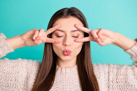 Close up photo of calm flirty lovely girl make v-signs send air kiss attract boyfriend have date wear pullover isolated over teal turquoise color backgroundの写真素材