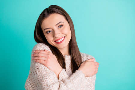Close up photo of charming candid girl hug herself dream have weekend rest relax wear knitted sweater isolated over teal turquoise color backgroundの写真素材