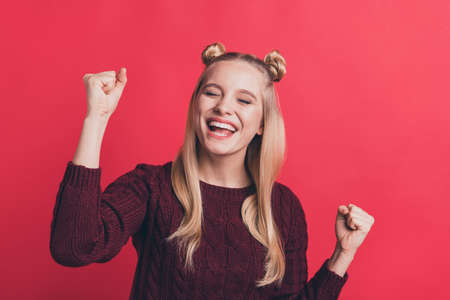 Closeup photo of crazy pretty lady overjoyed with great achievement raising fists air rejoicing wear knitted jumper isolated pastel red color backgroundの写真素材