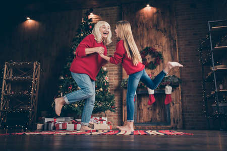 Full length body size view of nice attractive lovely cheerful cheery carefree granny pre-teen grandchild dancing having fun at decorated industrial brick wood loft style interior houseの写真素材