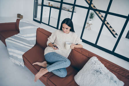 Top high above angle photo of concentrated girl sit on brown leather divan use phone read feednews...