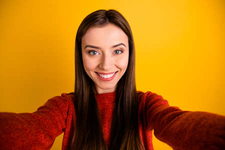 Close up photo of sweet positive cheerful girl make selfie feel content on autumn vacation wear style sweater isolated over yellow color backgroundの写真素材