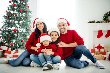 Portrait of cheerful family celebrating newyear enjoying winter december vacation weekend in light white interior living-roomの写真素材