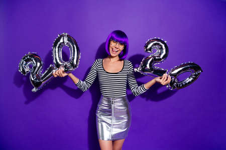 Photo of funny lady hold hands ballons new year party wear specs skirt striped pullover isolated purple backgroundの写真素材