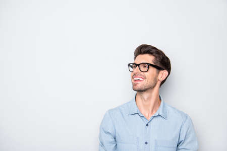 Photo of cheerful positive funky staring man looking into empty space wearing eyeglasses smiling...