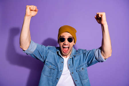 Photo of trendy white cheerful handsome shouting man screaming with hands up with fists made smiling...