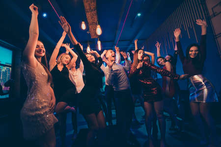 Having fun on disco party concept. Youth people wearing formalwear dress meeting celebrate event feel crazy rejoice dance moving on discotheque raise fists scream shoutの写真素材