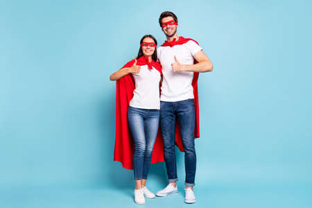 Full length body size view of nice attractive lovely content cheerful sporty people in red hero look hugging showing thumbup isolated on bright vivid shine vibrant blue turquoise backgroundの写真素材