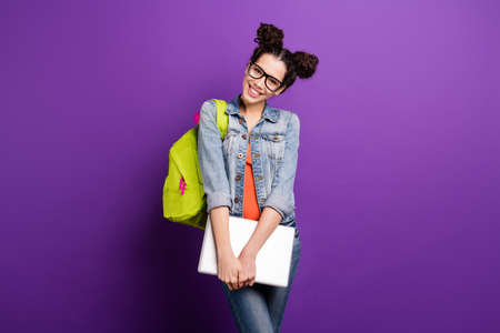 Portrait of sweet cute girlish high school girl ready for university seminar lecture hold computer wear casual style outfit isolated over violet color backgroundの写真素材