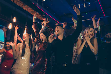 Photo of crazy chilling students dressed in formalwear putting their hands up rejoicing with party started faces with smile screaming shouting with happiness enjoying free timeの写真素材