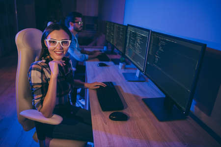 Profile photo of it specialist two guy lady business people love working late together at night watch monitors writing startup interface back-end code sitting chairs office indoorsの写真素材