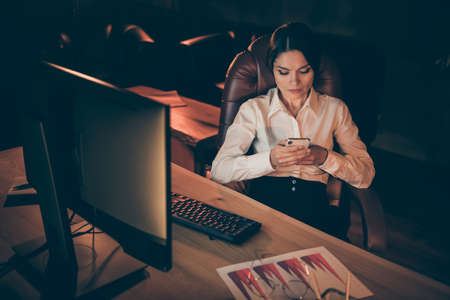 Portrait of her she nice attractive lovely stylish focused hard-working businesslady expert specialist checking message preparing plan strategy deadline at night dark work place stationの写真素材