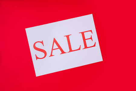 Photo of insription sale emphasized from white, piece of paper on red vivid color backgroundの写真素材