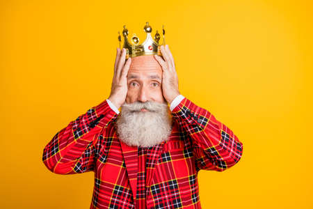 My precious. Photo of cool look grandpa white beard aged king holding diadem dont want give it to young prince wear crown red blazer tie outfit isolated yellow color backgroundの写真素材