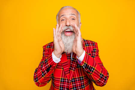 Photo of cool modern look grandpa with white beard yelling announcement loudly holding hands near mouth wear plaid red blazer tie clothes isolated yellow color backgroundの写真素材