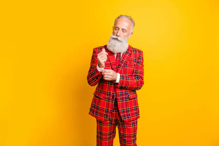 Portrait of his he nice handsome attractive virile masculine cool gray-haired man fixing cuff preparation isolated over bright vivid shine vibrant yellow color backgroundの写真素材