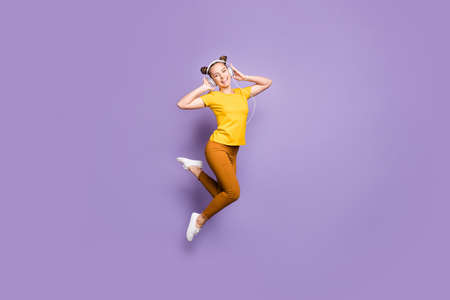 Full size photo of joyful lady jumping high listening modern youngster, playlist music through cool...