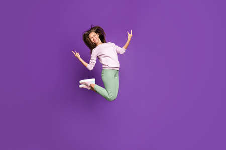 Full length body size view of her she nice attractive crazy overjoyed cheerful girl jumping having fun showing horns sign isolated on bright vivid shine vibrant purple violet lilac color backgroundの写真素材