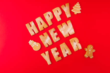 Greeting festive card concept. High angle view photo of three baked words elements figures tasty sweet congratulation x-mas composition made red backgroundの写真素材