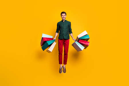 Full length photo of amazed funky crazy guy jump hear wonderful sales scream wow go shop buy...