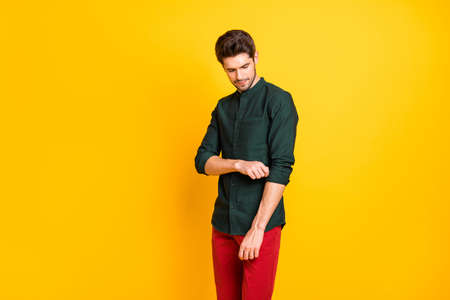 Portrait of focused serious guy want prepare for work job event correct his sleeves roll up wear casual style outfit isolated over yellow color backgroundの写真素材