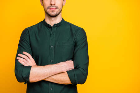 Photo of confident candid man in green shirt outfit standing confidently with hands folded having bristle on face expressing no emotions isolated vibrant color backgroundの写真素材