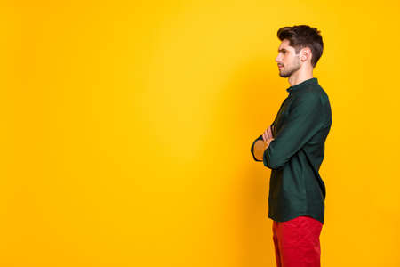 Profile side photo of confident cool serious guy entrepreneur listen solve work start-up problems cross hands look wear casual style outfit red pants trousers isolated over yellow color backgroundの写真素材