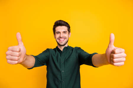Photo of cheerful positive handsome man smiling toothily showing you double thumb up recommending you shopping mall with sales isolated vivid color backgroundの写真素材
