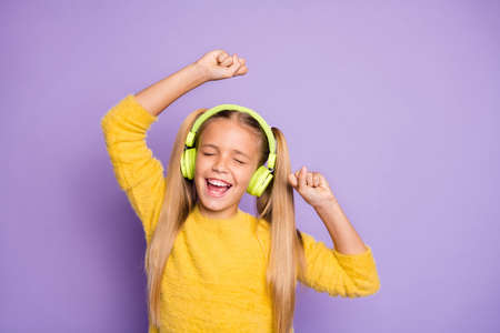 Portrait of funky crazy kid with ponytails listen music have break pause use headset sing song dance on party wear trendy jumper isolated over violet color backgroundの写真素材