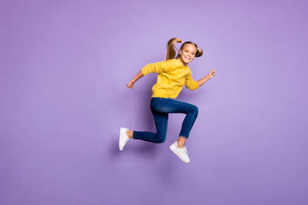 Full body photo of cheerful sweet kid jump run after black friday bargains wear casual style clothing isolated over purple color backgroundの写真素材