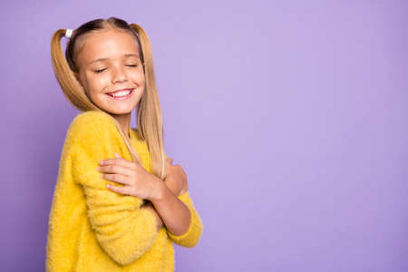 Photo of trendy cheerful toothy beaming girl hugging herself feeling comfortable isolated pastel violet color backgroundの写真素材